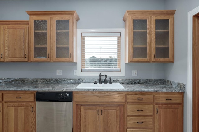 kitchen featuring stainless steel dishwasher, a sink, and glass insert cabinets