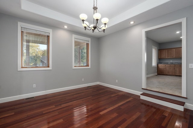 unfurnished room with a notable chandelier, baseboards, recessed lighting, visible vents, and dark wood finished floors