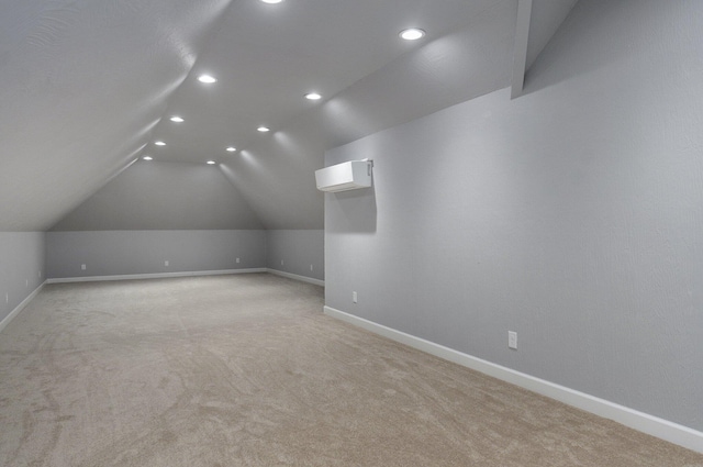 bonus room with a wall unit AC, light colored carpet, vaulted ceiling, recessed lighting, and baseboards