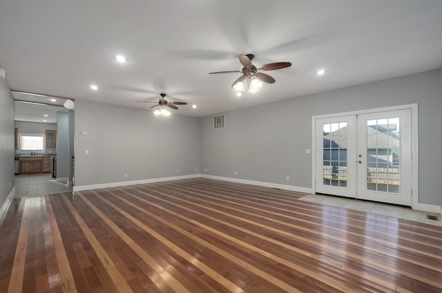 unfurnished living room featuring visible vents, ceiling fan, a wealth of natural light, recessed lighting, and hardwood / wood-style floors