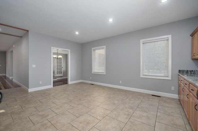 unfurnished living room featuring a notable chandelier, baseboards, recessed lighting, light tile patterned floors, and visible vents