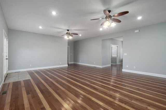 empty room with dark wood-style flooring, baseboards, and a ceiling fan