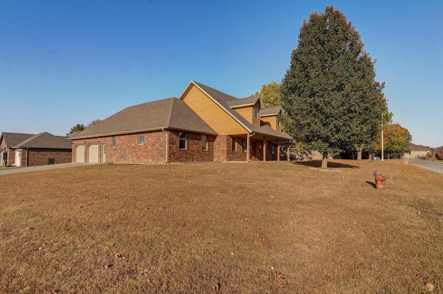 view of front of property with a garage, a front yard, driveway, and brick siding