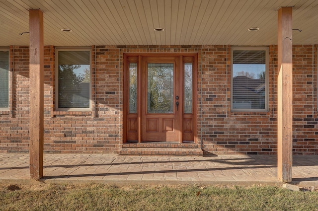 doorway to property featuring brick siding
