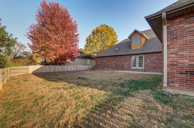 view of yard with french doors and a fenced backyard