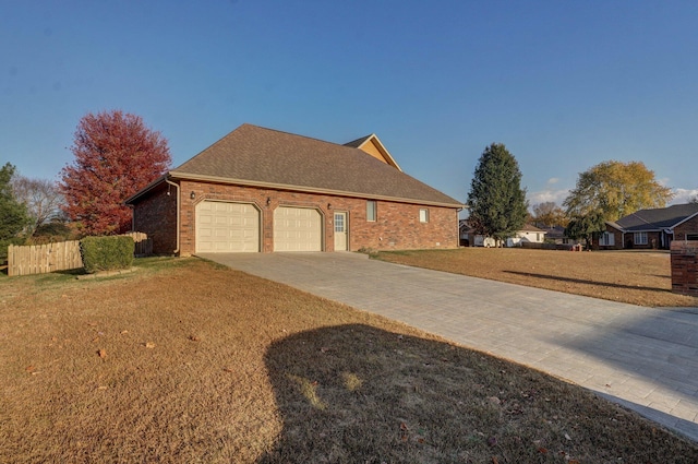 view of home's exterior featuring driveway, brick siding, a garage, a yard, and fence
