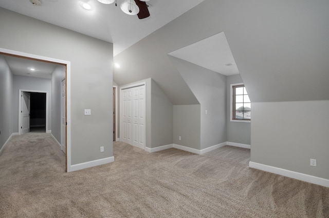 bonus room featuring baseboards, a ceiling fan, light carpet, and lofted ceiling