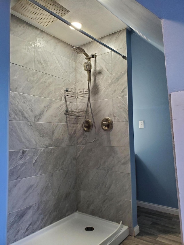 2111 N Grant Ave, Springfield, MO 65803 - bathroom featuring tiled shower, wood finished floors, and baseboards