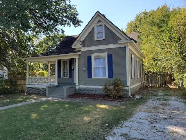 2111 N Grant Ave, Springfield, MO 65803 - bungalow with roof with shingles, a porch, fence, and a front lawn