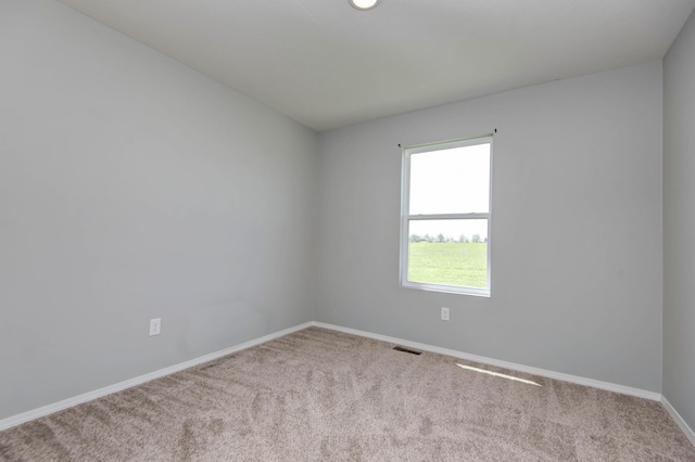 empty room featuring visible vents, baseboards, and carpet floors