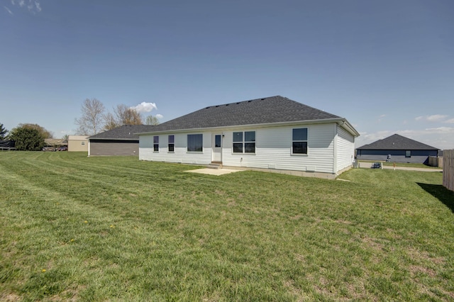 back of house with a yard, a patio, and roof with shingles