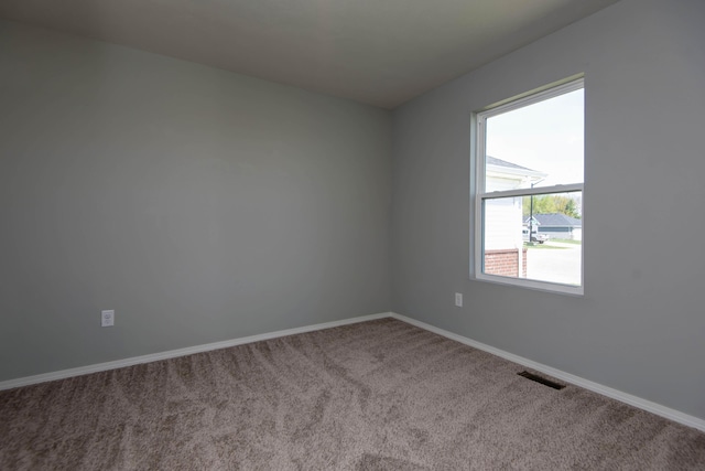 unfurnished room with carpet flooring, baseboards, and visible vents