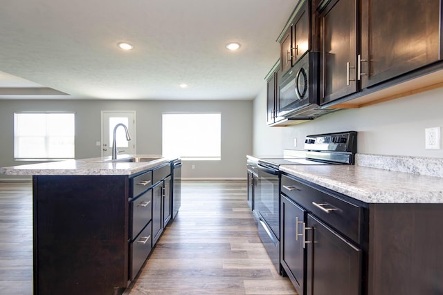 kitchen featuring recessed lighting, light wood-style flooring, light countertops, stainless steel appliances, and a sink