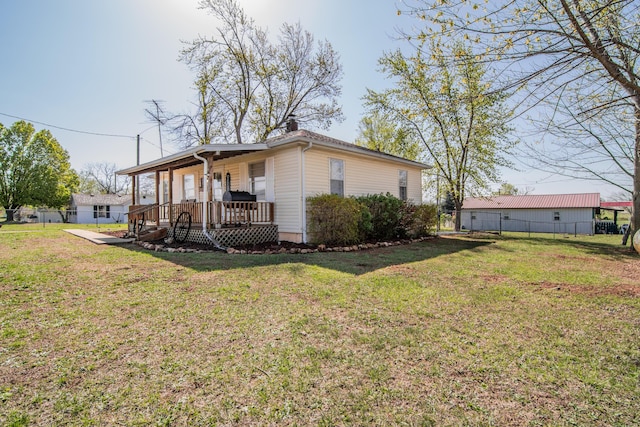 317 W 1st St, Miller, MO 65707 - view of property exterior with fence, a lawn, and covered porch