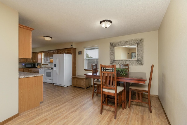 1431 Isdell St, Bolivar, MO 65613 - dining space with light wood-type flooring, baseboards, and a textured ceiling