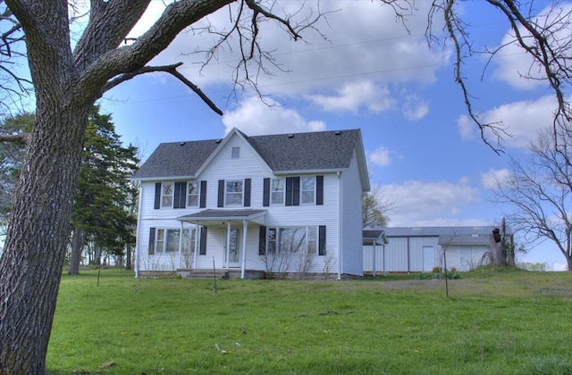 colonial-style house with roof with shingles and a front lawn