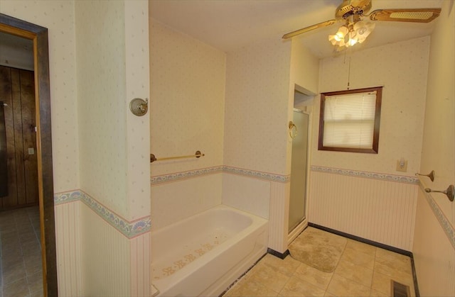 full bathroom featuring ceiling fan, a shower stall, visible vents, wainscoting, and wallpapered walls