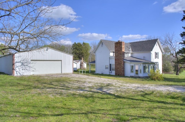 view of side of home featuring a lawn, a garage, a chimney, an outdoor structure, and roof with shingles