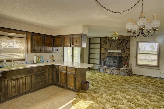 kitchen featuring a textured ceiling, light countertops, a sink, and a healthy amount of sunlight
