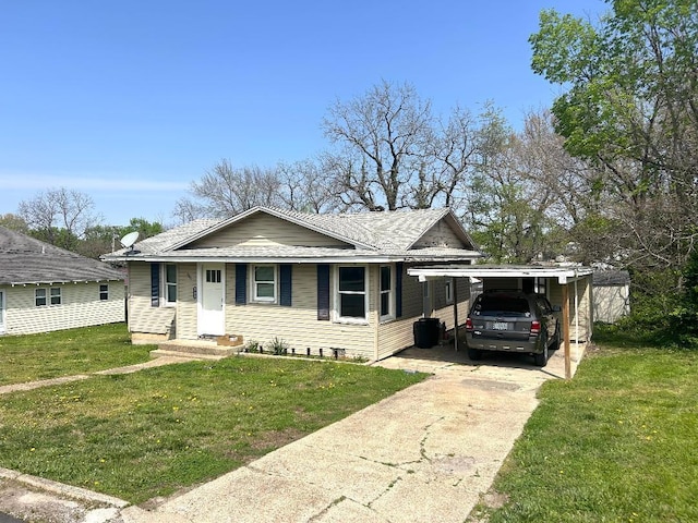 bungalow-style house featuring driveway, an attached carport, and a front lawn
