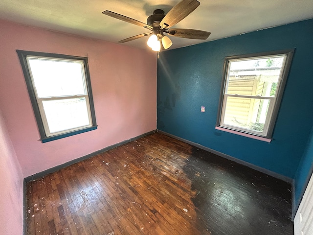 spare room featuring baseboards, a ceiling fan, and hardwood / wood-style floors