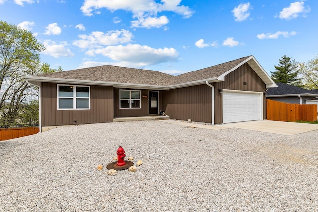 view of front of home featuring driveway, a garage, fence, and roof with shingles
