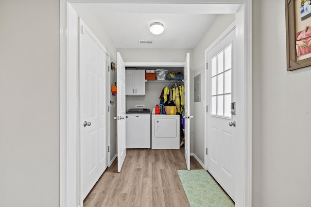 laundry area with visible vents, electric panel, light wood-style floors, independent washer and dryer, and cabinet space