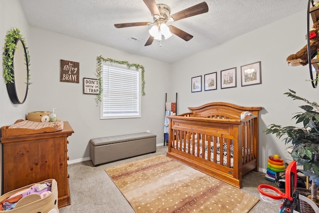 carpeted bedroom featuring visible vents, a textured ceiling, baseboards, and ceiling fan