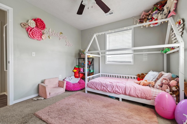 carpeted bedroom with visible vents, baseboards, and a ceiling fan
