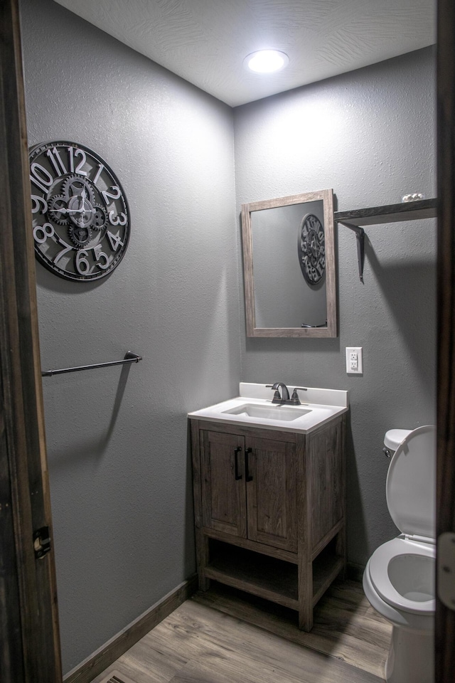 203 E Steel St, Seymour, MO 65746 - half bathroom featuring wood finished floors, vanity, toilet, and baseboards