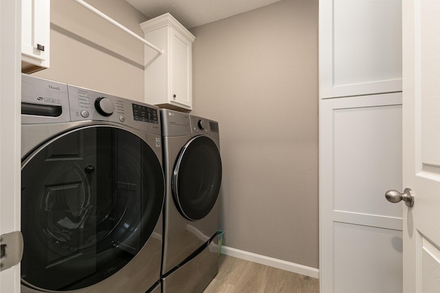 760 W Stewart St, Bolivar, MO 65613 - clothes washing area featuring washer and clothes dryer, light wood-style floors, cabinet space, and baseboards