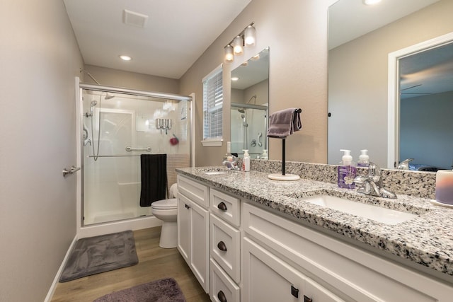 760 W Stewart St, Bolivar, MO 65613 - bathroom with wood finished floors, a shower stall, double vanity, toilet, and recessed lighting