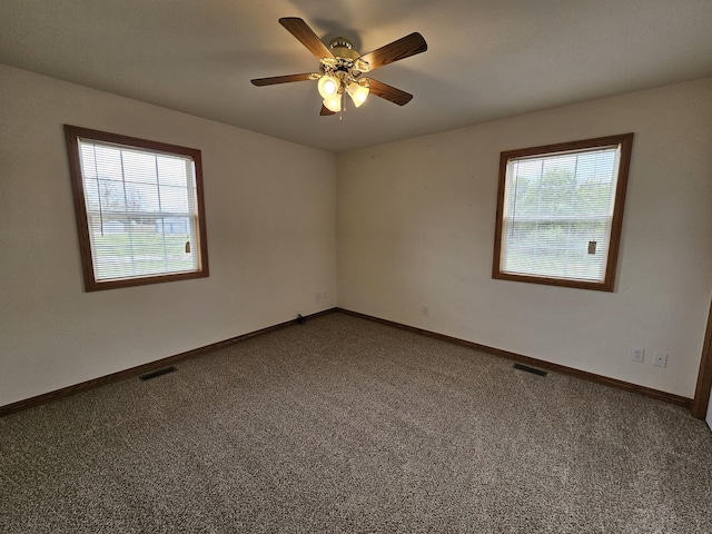 unfurnished room with baseboards, a ceiling fan, visible vents, and carpet