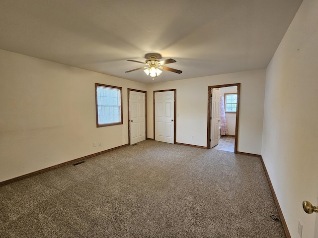 unfurnished bedroom with connected bathroom, ceiling fan, baseboards, and carpet flooring