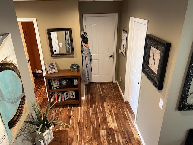 hallway featuring wood finished floors and baseboards