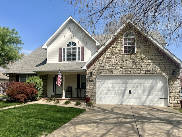 traditional-style house featuring concrete driveway, a garage, stone siding, and covered porch