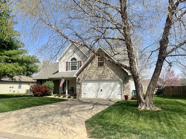 traditional-style house featuring stone siding, a garage, fence, a front lawn, and driveway
