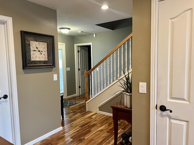 entryway featuring stairway, dark wood-style floors, and baseboards