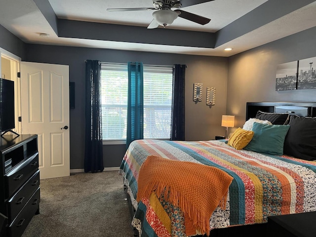 carpeted bedroom featuring baseboards, a raised ceiling, recessed lighting, and a ceiling fan