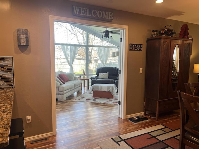 living area with visible vents, baseboards, recessed lighting, and wood finished floors