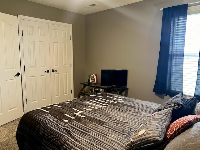 bedroom featuring a closet, visible vents, and carpet floors