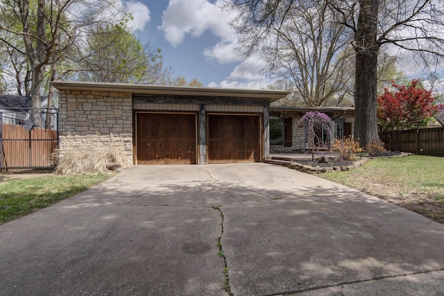 view of front of property with fence, stone siding, a garage, and concrete driveway