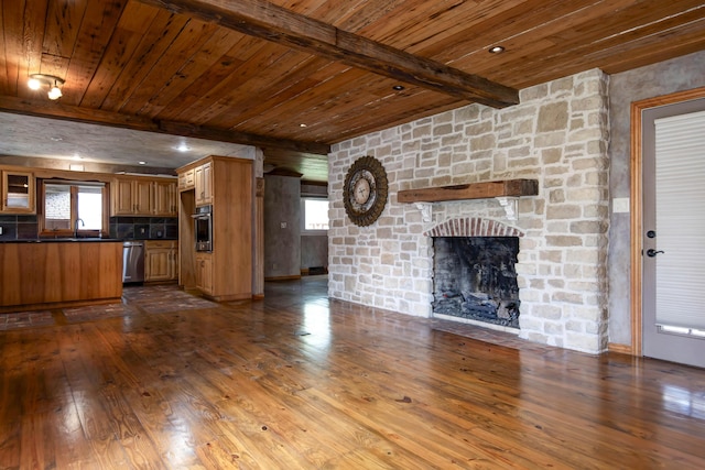 unfurnished living room with wood ceiling, beamed ceiling, a sink, and dark wood finished floors