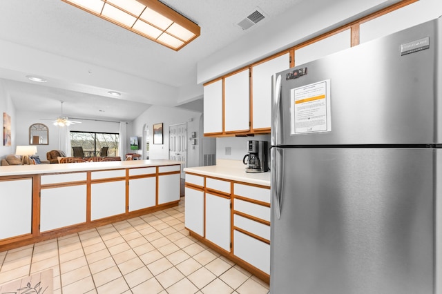 350 S Wildwood Dr Unit 21, Branson, MO 65616 - kitchen featuring open floor plan, light countertops, freestanding refrigerator, white cabinetry, and visible vents