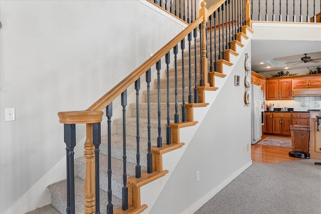 500 Navajo Trl, Kimberling City, MO 65686 - staircase with carpet floors, baseboards, a ceiling fan, and a towering ceiling
