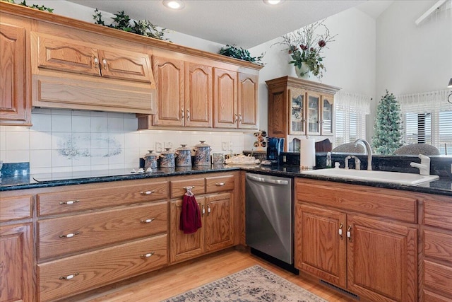 500 Navajo Trl, Kimberling City, MO 65686 - kitchen with stainless steel dishwasher, light wood-style flooring, a sink, brown cabinets, and decorative backsplash