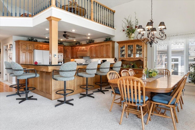 500 Navajo Trl, Kimberling City, MO 65686 - dining area featuring light colored carpet, recessed lighting, a high ceiling, and ceiling fan with notable chandelier
