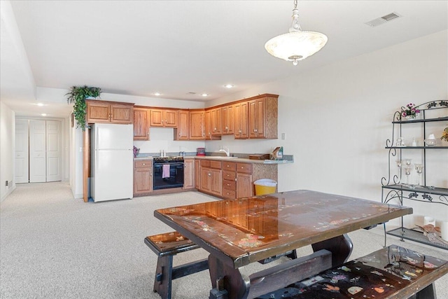 500 Navajo Trl, Kimberling City, MO 65686 - kitchen featuring freestanding refrigerator, visible vents, light carpet, a sink, and oven