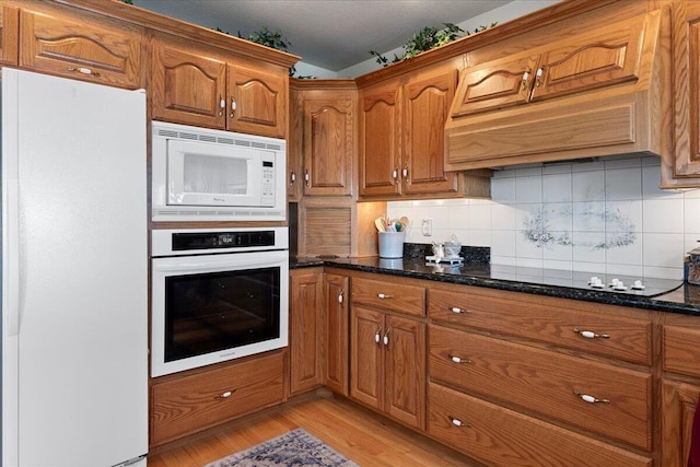 500 Navajo Trl, Kimberling City, MO 65686 - kitchen featuring brown cabinetry, dark stone counters, light wood finished floors, and white appliances