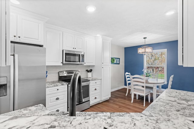 704 E Waterford Blvd, Ozark, MO 65721 - kitchen with stainless steel appliances, white cabinetry, baseboards, and wood finished floors